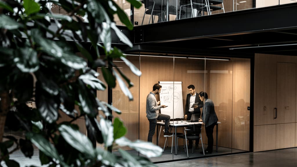 Salle de réunion vitrée au sein d'un campus de bureaux favorisant la collaboration, l'innovation et le travail d'équipe.