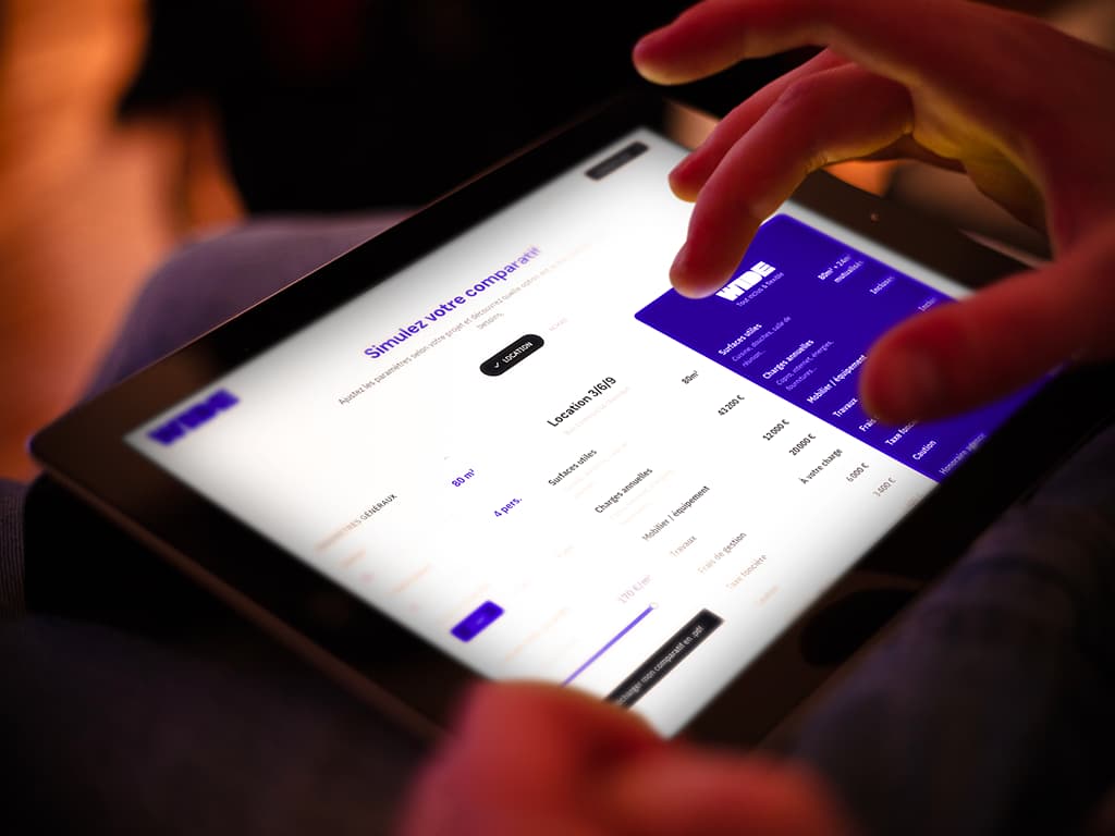 Utilisateur consultant le simulateur de coûts WIDE sur tablette pour comparer un bureau opéré avec une location de bureaux classique en bail 3-6-9.