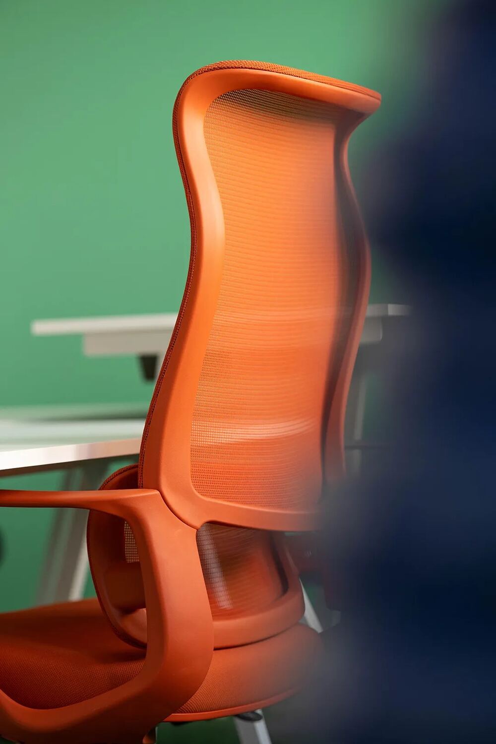 Fauteuil de bureau orange devant un mur vert