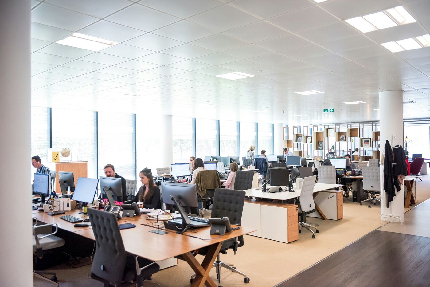Plateau de bureaux ouvert, collaborateurs à leurs postes de travail