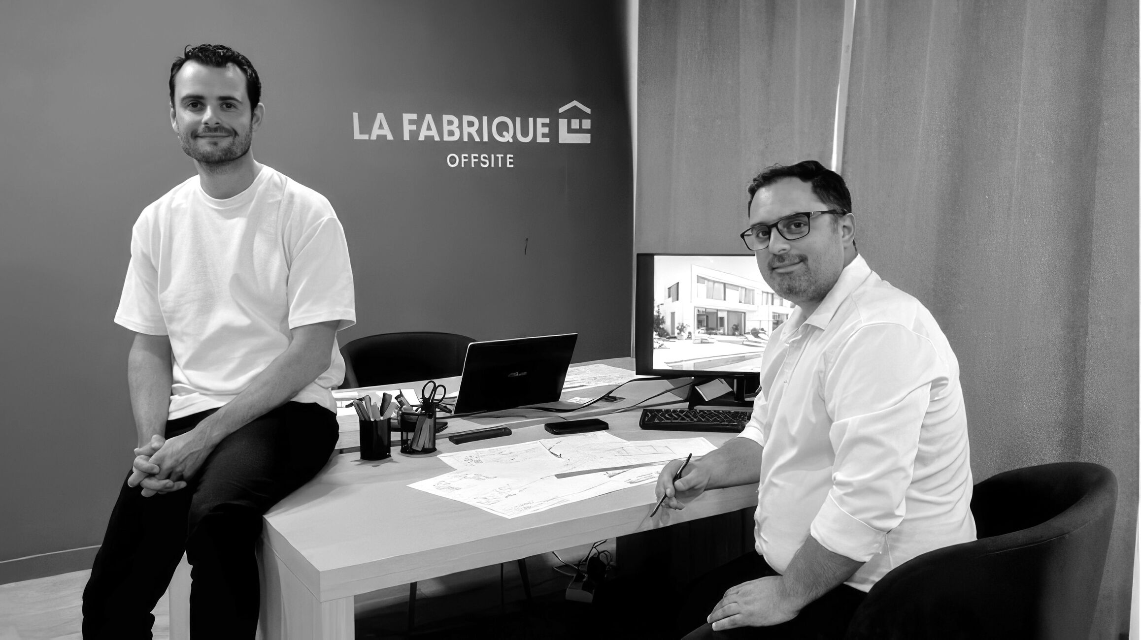Deux personnes assises à un bureau dans les locaux de La Fabrique Offsite